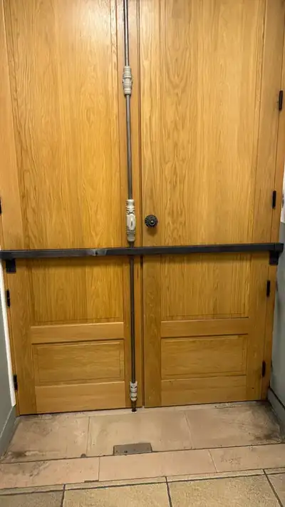 Barre de renfort intérieure en acier sur une porte bois à deux vantaux