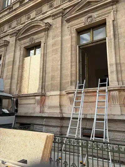 Mise en sécurité d'une fenêtre par pose de contreplaqué, échelles en place
