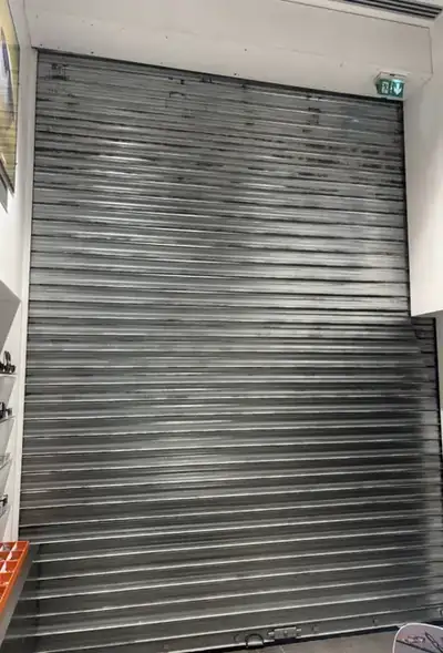 Rideau métallique motorisé à lames pleines fermé sur une vitrine
