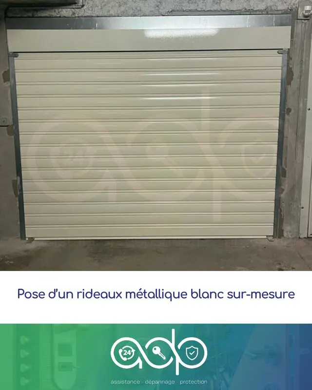 Rideau métallique blanc sur mesure posé dans l'entrée d'un garage en sous-sol.